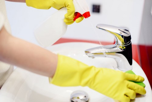 Technician applying carpet cleaning treatment with protective equipment